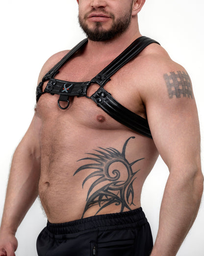 Man wearing a black leather harness with a white background